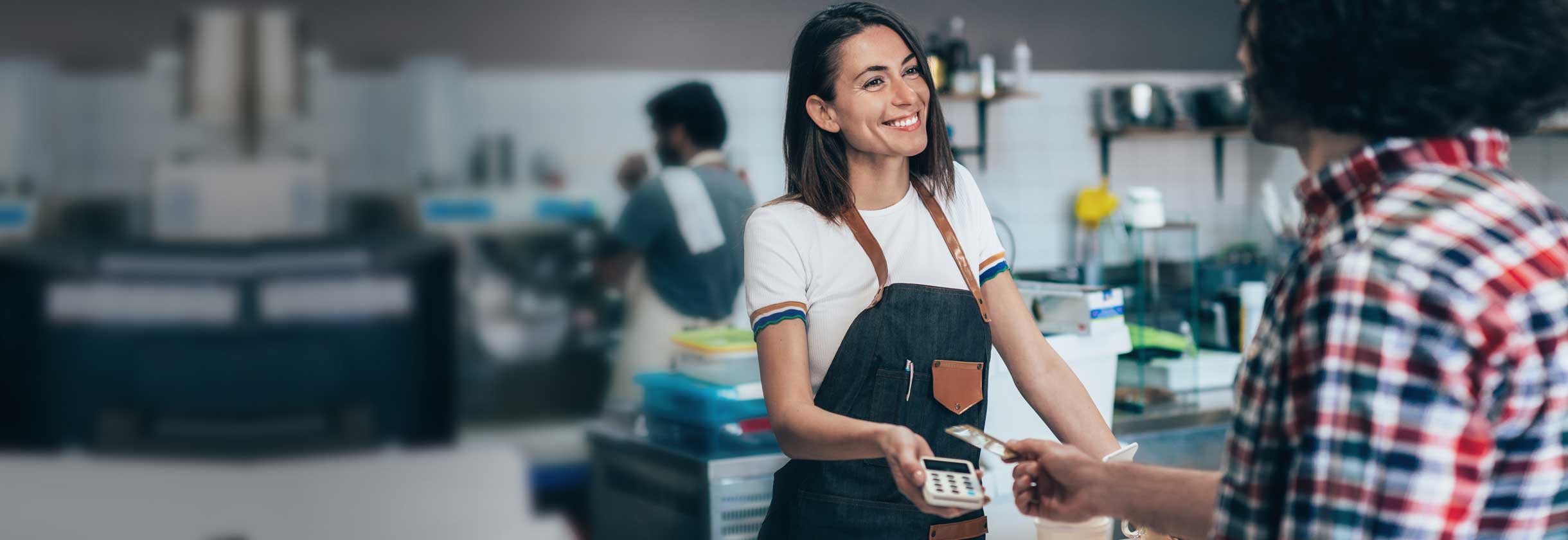 Cashier handing customer the payment processer